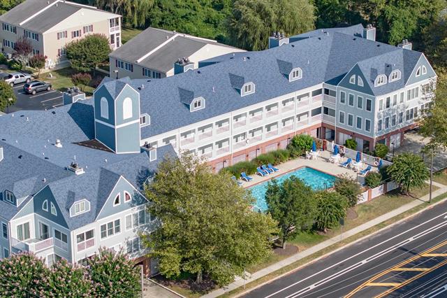 Aerial view of a condominium building with a central swimming pool